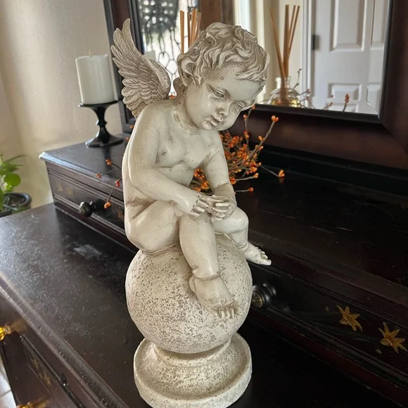 Resin angel statue on a ball 14 1/2 tall 8” wide cream colored